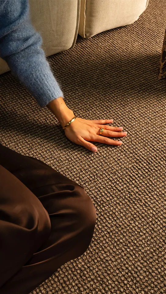 Woman sitting on brown rug