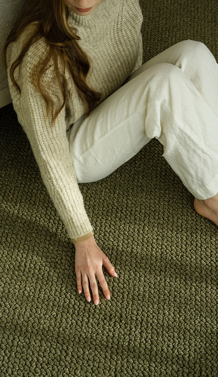 Woman sitting on green rug